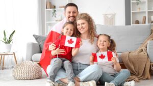 A happy family holding Canadian flags